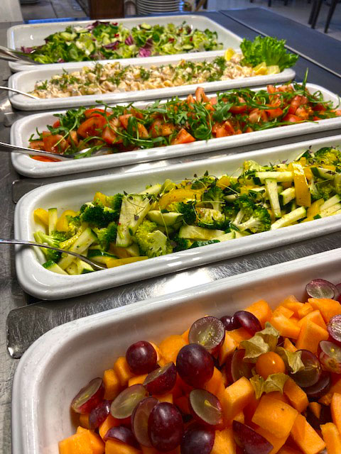 Five different colourful salads on display.