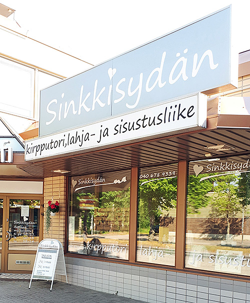 The facade of Sinkkisydän. Large windows displaying interior design products.