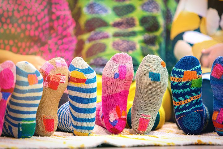 Lapsilla on jaloissaan värikkäitä parsittuja villasukkia.
