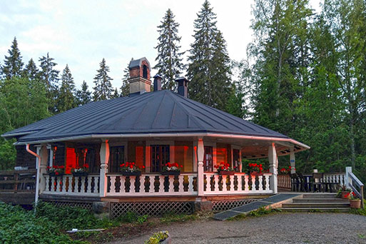 Viinitupa vuorenmaja. Punainen pyöreänmallinen hiihtomaja, kauniit valkoiset terassinkaiteet.