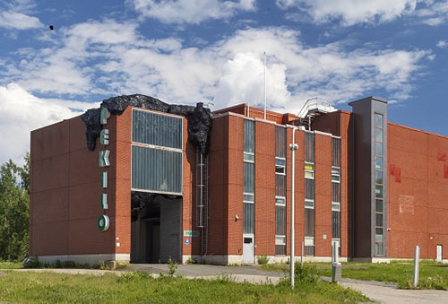 The main site of the Mänttä Art Festival is Pekilo, a large industrial building made of brick. There is a blue sky in the background. 
