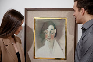 Nainen ja mies ihailevat Helene Schjerfbeckin öljymaalausta Punaposkinen tyttö 1927.
