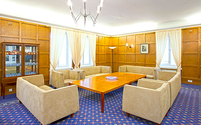 Six beige sofas around a table.