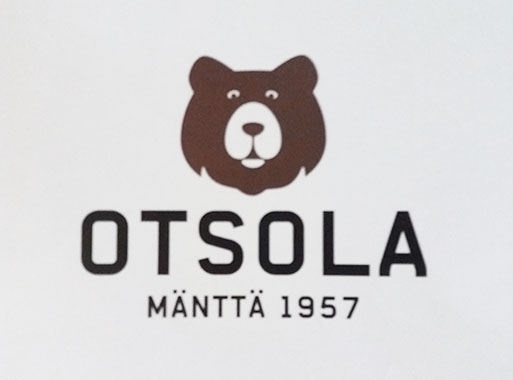 Tuulanmajoituksen logo, ruskea karhun pää, jonka alla mustalla teksti Otsola - Mänttä 1957 vaaleanharmaalla pohjalla